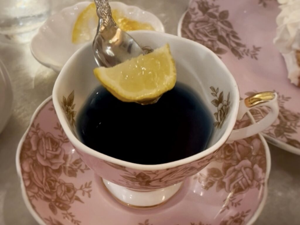 レモンスライスが浮かぶ紅茶が花柄のカップに注がれてテーブルに置かれている。