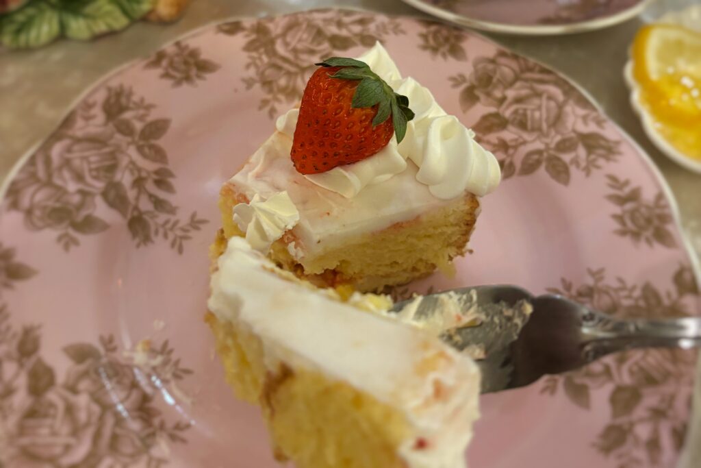 クリームといちごがトッピングされた黄色いスポンジケーキがお皿の上に置かれている